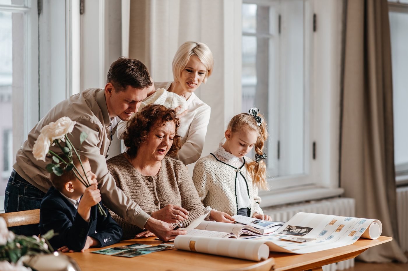 A family studies an unfolded family tree around the table